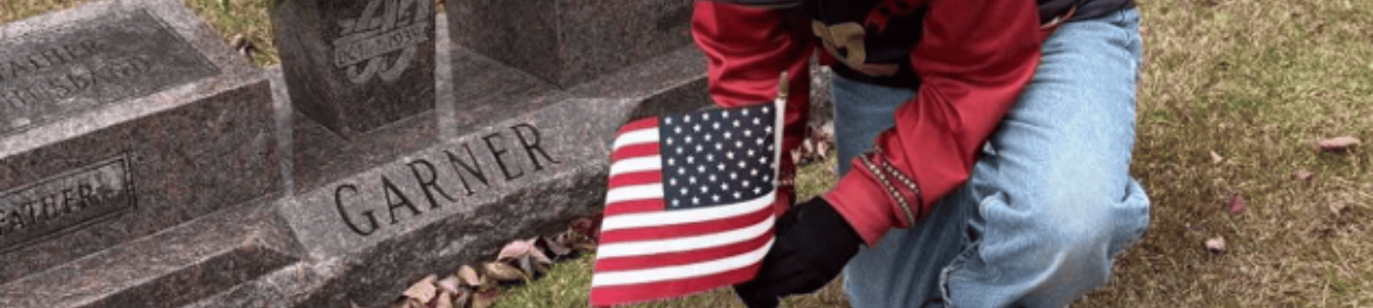 Scout places flag on grave